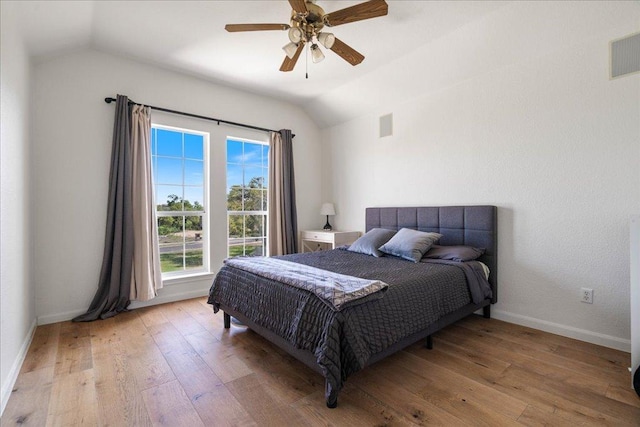 bedroom featuring vaulted ceiling, wood-type flooring, baseboards, and a ceiling fan