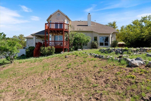 rear view of property featuring a wooden deck and a chimney
