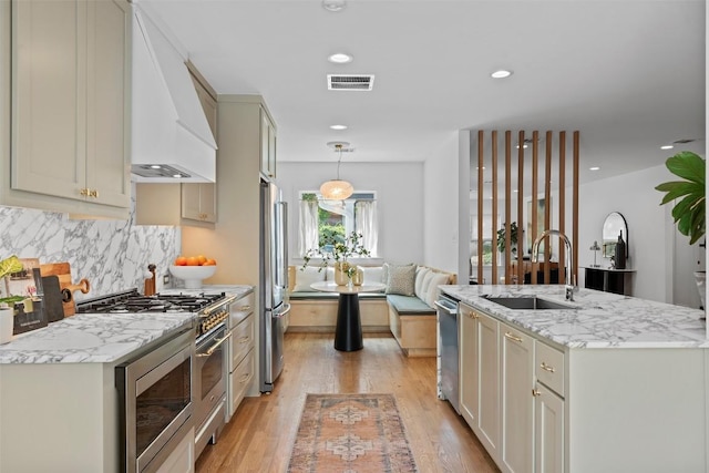 2004 Raleigh Ave, Austin, TX 78703 - kitchen featuring stainless steel appliances, premium range hood, tasteful backsplash, light wood-style floors, and recessed lighting