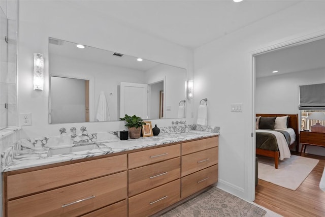 2004 Raleigh Ave, Austin, TX 78703 - ensuite bathroom featuring double vanity, wood finished floors, and recessed lighting