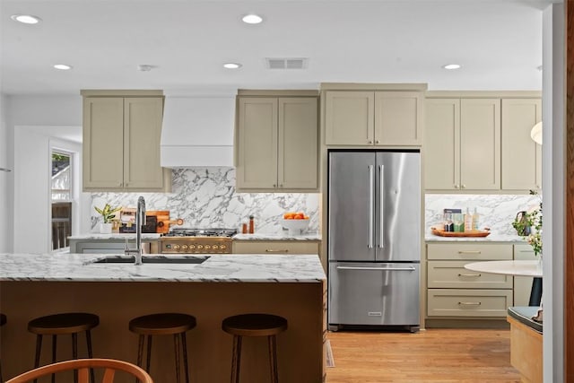 2004 Raleigh Ave, Austin, TX 78703 - kitchen with high end fridge, custom exhaust hood, decorative backsplash, a kitchen bar, and recessed lighting
