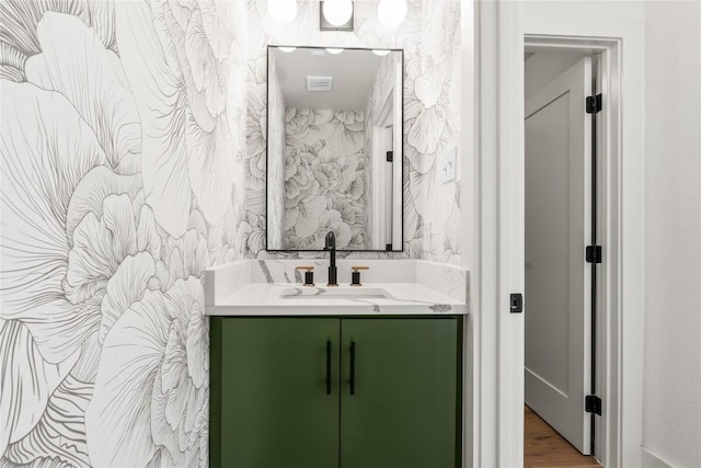 bathroom with wallpapered walls, vanity, and visible vents