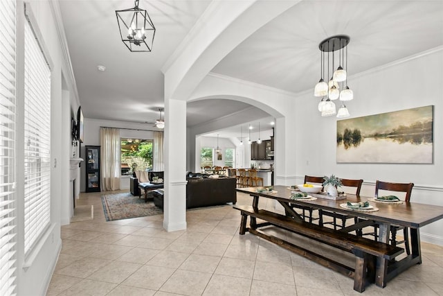 174 Challis Ct, Austin, TX 78737 - dining space with a chandelier, crown molding, arched walkways, ceiling fan, and light tile patterned floors