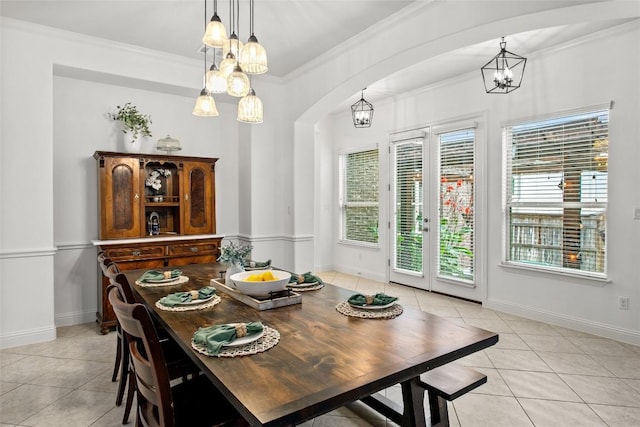 174 Challis Ct, Austin, TX 78737 - dining area featuring light tile patterned floors, a chandelier, arched walkways, crown molding, and french doors