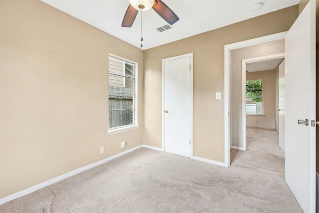 unfurnished bedroom featuring baseboards, a ceiling fan, visible vents, and carpet