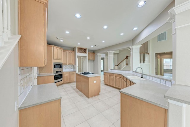 8105 Endeavor Cir, Austin, TX 78726 - kitchen featuring appliances with stainless steel finishes, ornate columns, decorative backsplash, light tile patterned floors, and recessed lighting