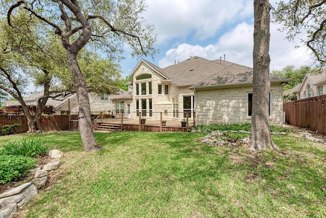 8105 Endeavor Cir, Austin, TX 78726 - back of house with stone siding, a fenced backyard, a wooden deck, and a shingled roof