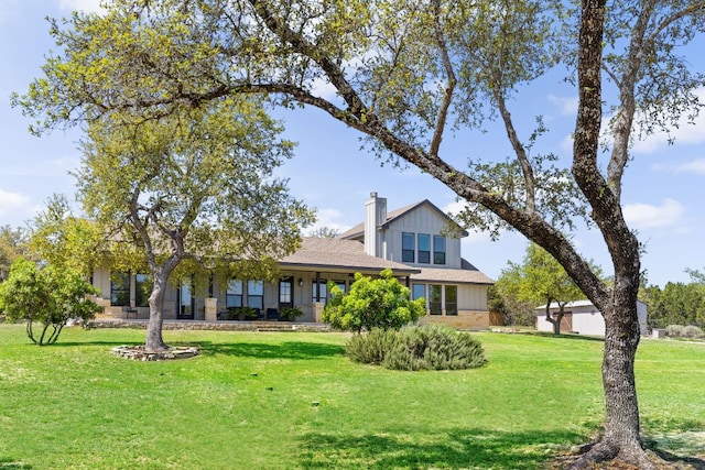 18105 Austin Blvd, Lago Vista, TX 78645 - view of front facade featuring a chimney, a front yard, board and batten siding, and roof with shingles