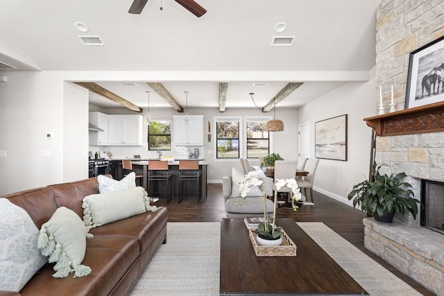 18105 Austin Blvd, Lago Vista, TX 78645 - living room featuring ceiling fan, dark wood finished floors, a fireplace, and beam ceiling
