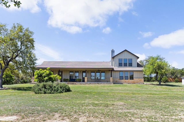 18105 Austin Blvd, Lago Vista, TX 78645 - view of front of house with a front lawn, a chimney, board and batten siding, and a porch