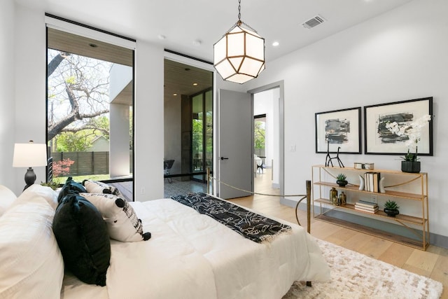 bedroom featuring visible vents, wood finished floors, and multiple windows