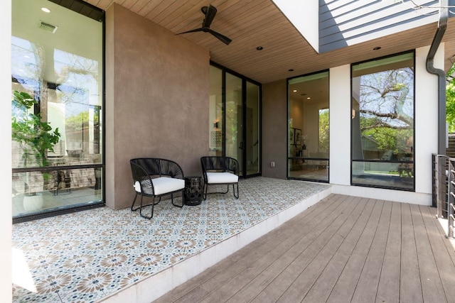 wooden terrace with a ceiling fan and visible vents