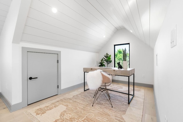office area featuring baseboards, lofted ceiling, and light wood-style floors
