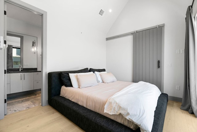 bedroom with ensuite bath, visible vents, a sink, light wood-style floors, and recessed lighting