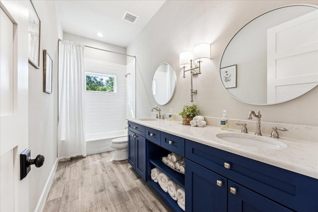 3204 Whitt Creek Trl, Leander, TX 78641 - bathroom featuring wood finished floors, toilet, shower / bathtub combination with curtain, and double vanity