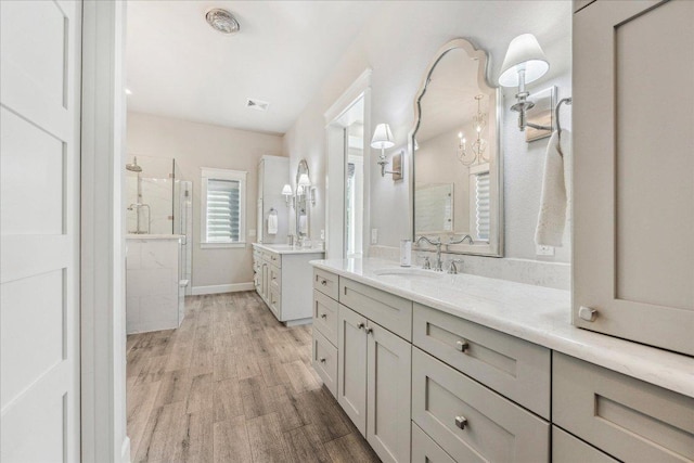 3204 Whitt Creek Trl, Leander, TX 78641 - full bathroom featuring a stall shower, wood finished floors, two vanities, and baseboards