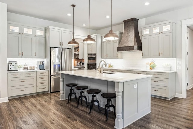 3204 Whitt Creek Trl, Leander, TX 78641 - kitchen featuring custom exhaust hood, appliances with stainless steel finishes, a sink, tasteful backsplash, and a kitchen island with sink