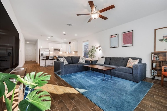living area featuring wood finish floors, a ceiling fan, visible vents, and recessed lighting