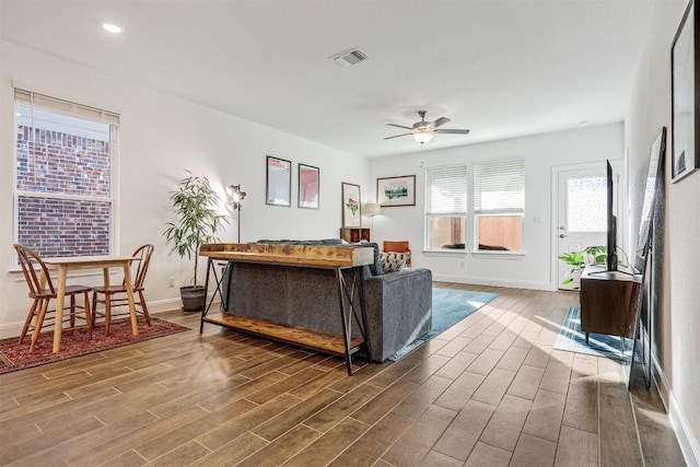 living area with visible vents, baseboards, ceiling fan, dark wood finished floors, and recessed lighting