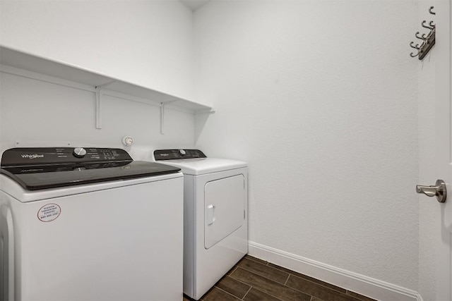 laundry area with washer and dryer, laundry area, baseboards, and wood finish floors