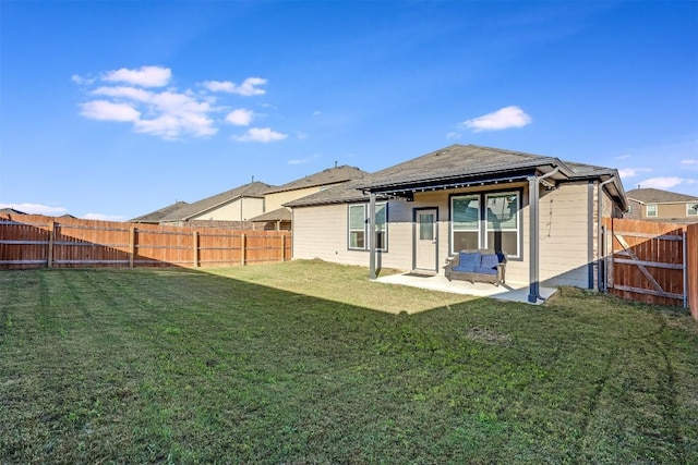 rear view of house with a fenced backyard, a patio, and a lawn
