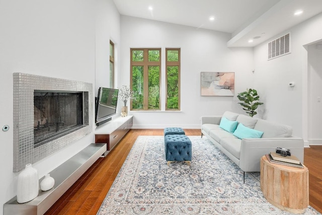 603 Westwood Ter, Austin, TX 78746 - living area featuring vaulted ceiling, wood finished floors, a fireplace with raised hearth, visible vents, and recessed lighting