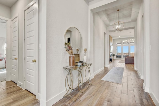 518 Bay Breeze Dr, Kyle, TX 78640 - hall featuring a chandelier, wood finished floors, and a raised ceiling