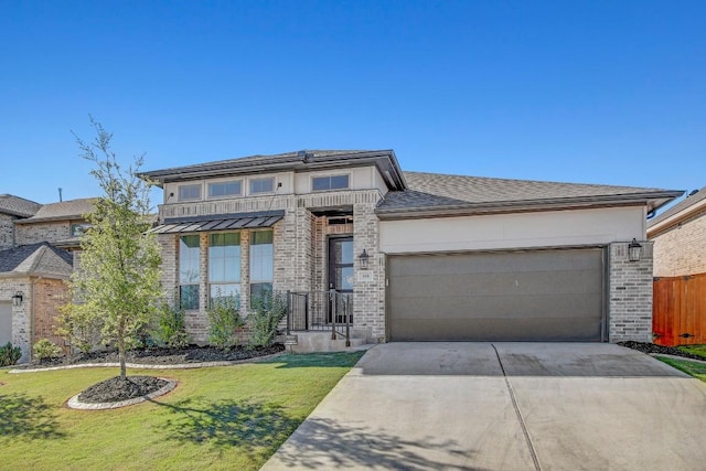 prairie-style house with stucco siding, driveway, an attached garage, a front lawn, and brick siding