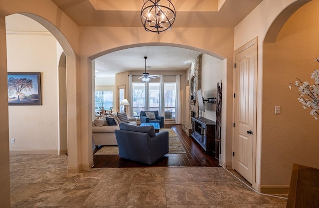 2705 Sixpence Ln, Pflugerville, TX 78660 - living room featuring ceiling fan, baseboards, arched walkways, a chandelier, and a textured wall