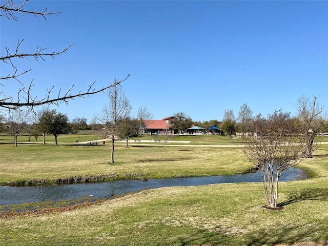 view of community with a lawn and a water view