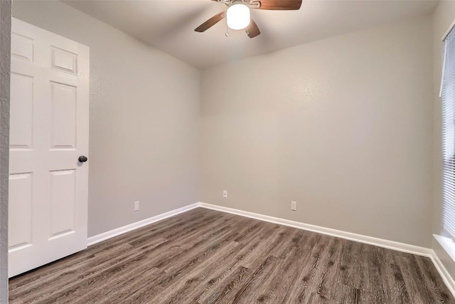 empty room featuring dark wood finished floors, baseboards, and a ceiling fan