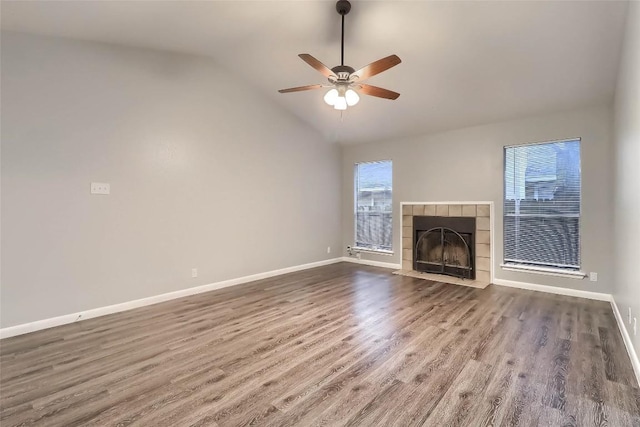 unfurnished living room with a ceiling fan, vaulted ceiling, wood finished floors, and baseboards