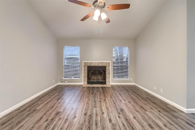 unfurnished living room featuring a fireplace, ceiling fan, dark wood finished floors, and baseboards
