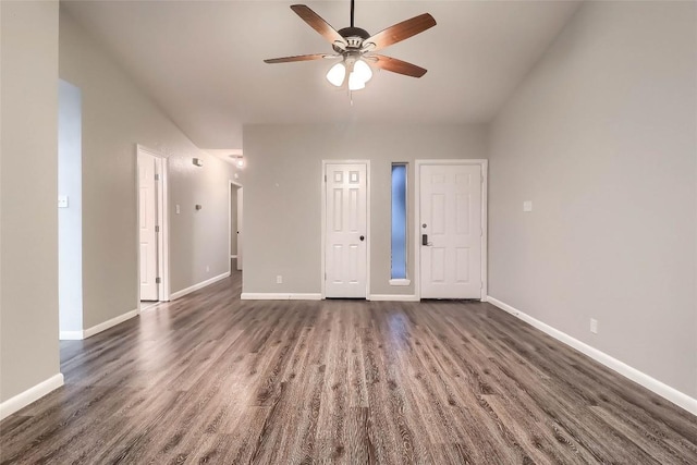 empty room featuring a ceiling fan, dark wood finished floors, and baseboards
