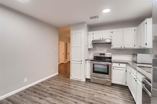 kitchen with under cabinet range hood, visible vents, white cabinets, appliances with stainless steel finishes, and wood finished floors