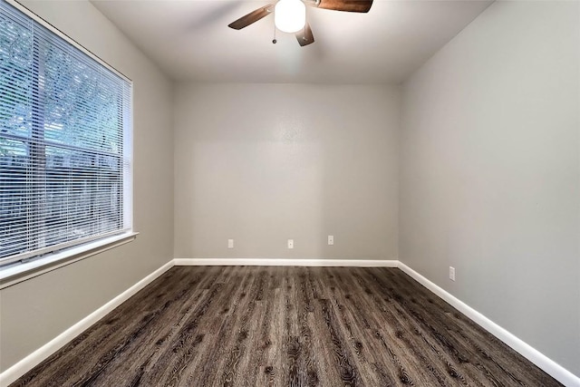 spare room with dark wood finished floors, baseboards, and a ceiling fan
