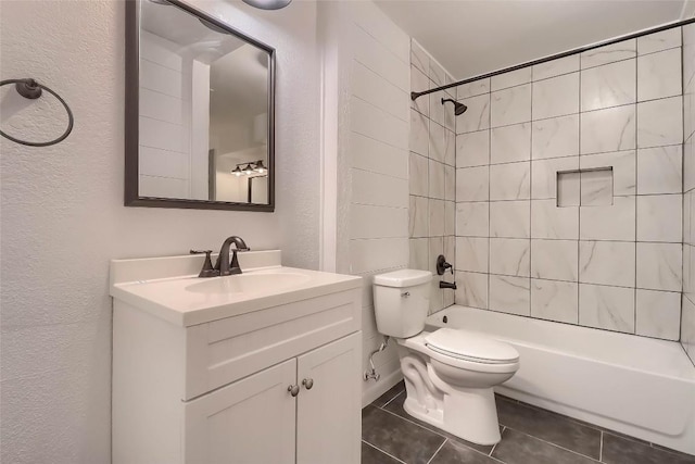 bathroom with tile patterned flooring, toilet, a textured wall, vanity, and tub / shower combination