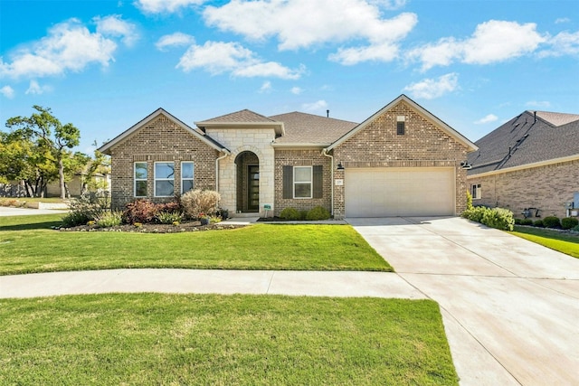 128 Mountain Lion Rd, Georgetown, TX 78628 - french country home featuring an attached garage, a front yard, driveway, stone siding, and brick siding