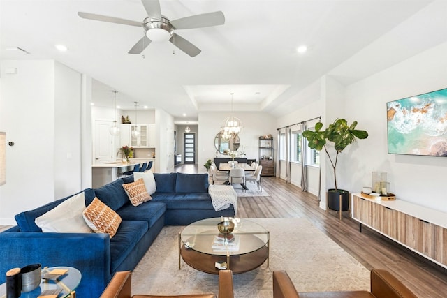 128 Mountain Lion Rd, Georgetown, TX 78628 - living area featuring light wood-style floors, ceiling fan, recessed lighting, a raised ceiling, and a chandelier
