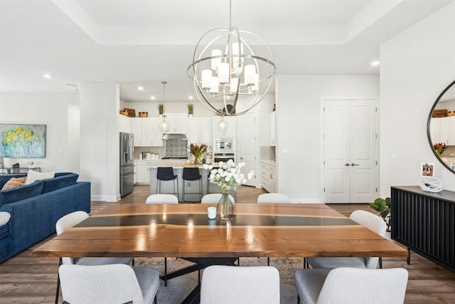 128 Mountain Lion Rd, Georgetown, TX 78628 - dining space featuring a chandelier, a raised ceiling, wood finished floors, and recessed lighting