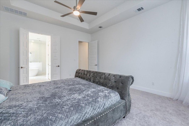 298 Canal Dr, Dripping Springs, TX 78620 - carpeted bedroom featuring baseboards, a tray ceiling, ensuite bath, and ceiling fan