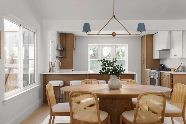 dining area with light wood finished floors and baseboards