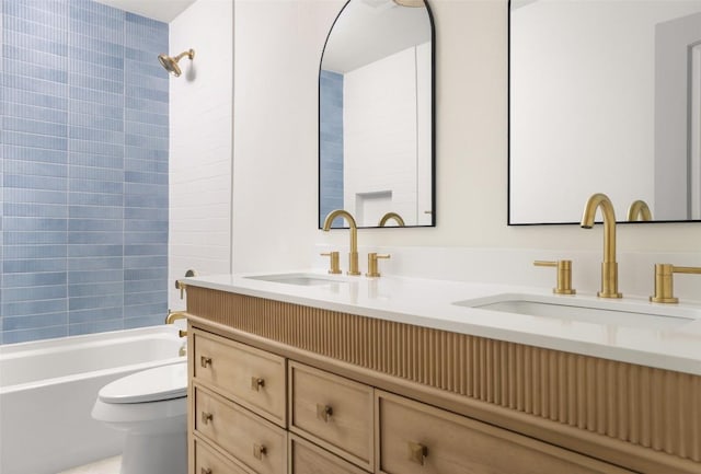 bathroom featuring toilet, double vanity, and shower / tub combination