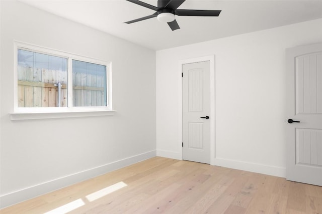 unfurnished bedroom featuring baseboards, wood finished floors, and a ceiling fan