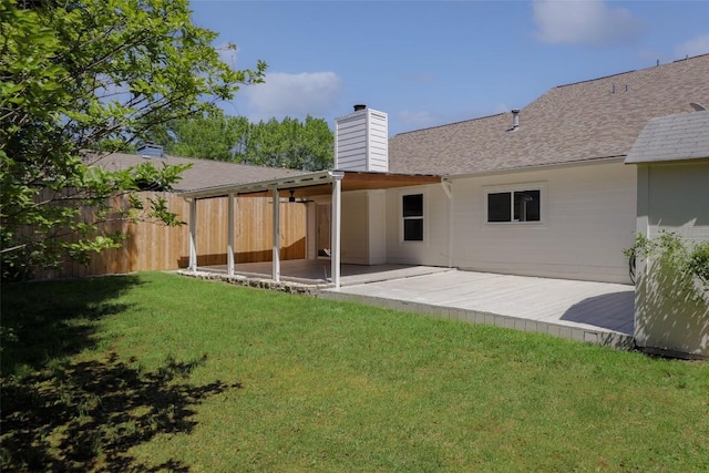 rear view of property featuring a chimney, a patio area, and roof with shingles
