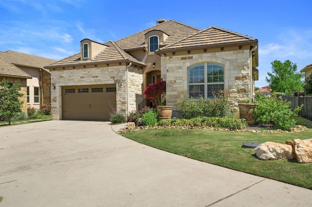 109 Grand Oaks Ln, Georgetown, TX 78628 - french country home with stone siding, an attached garage, driveway, and a tile roof