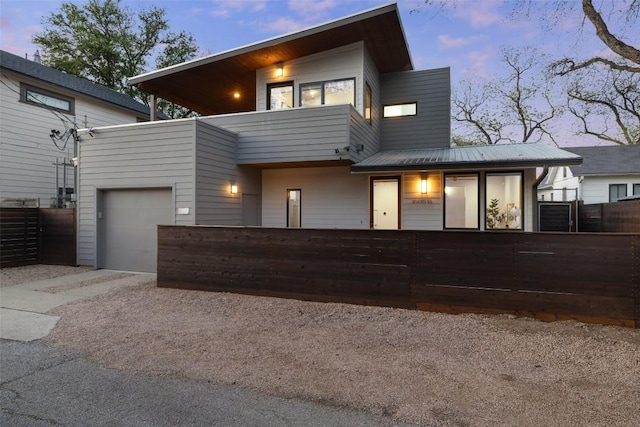 1605 Willow St Unit B, Austin, TX 78702 - modern home with concrete driveway, metal roof, a balcony, and a fenced front yard