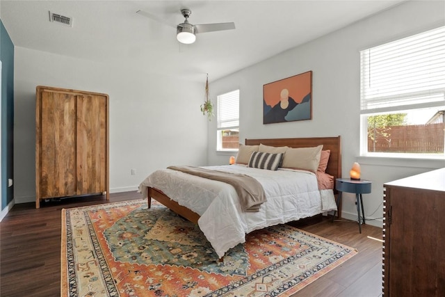 bedroom with baseboards, visible vents, ceiling fan, and dark wood-type flooring
