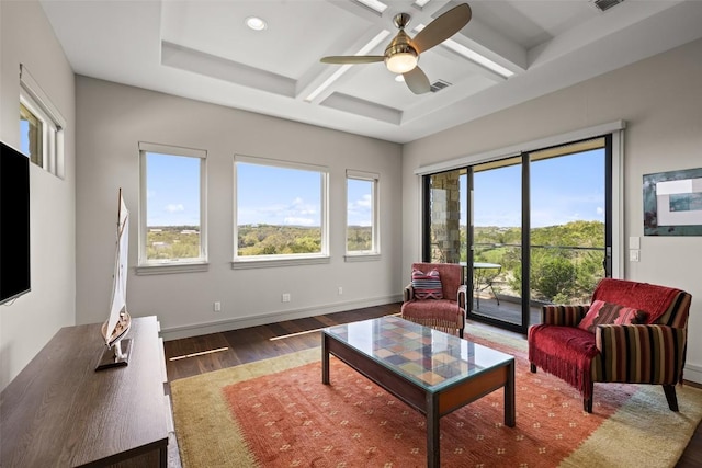 living area featuring ceiling fan, wood finished floors, coffered ceiling, and a healthy amount of sunlight