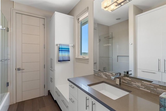 bathroom with decorative backsplash, walk in shower, and vanity
